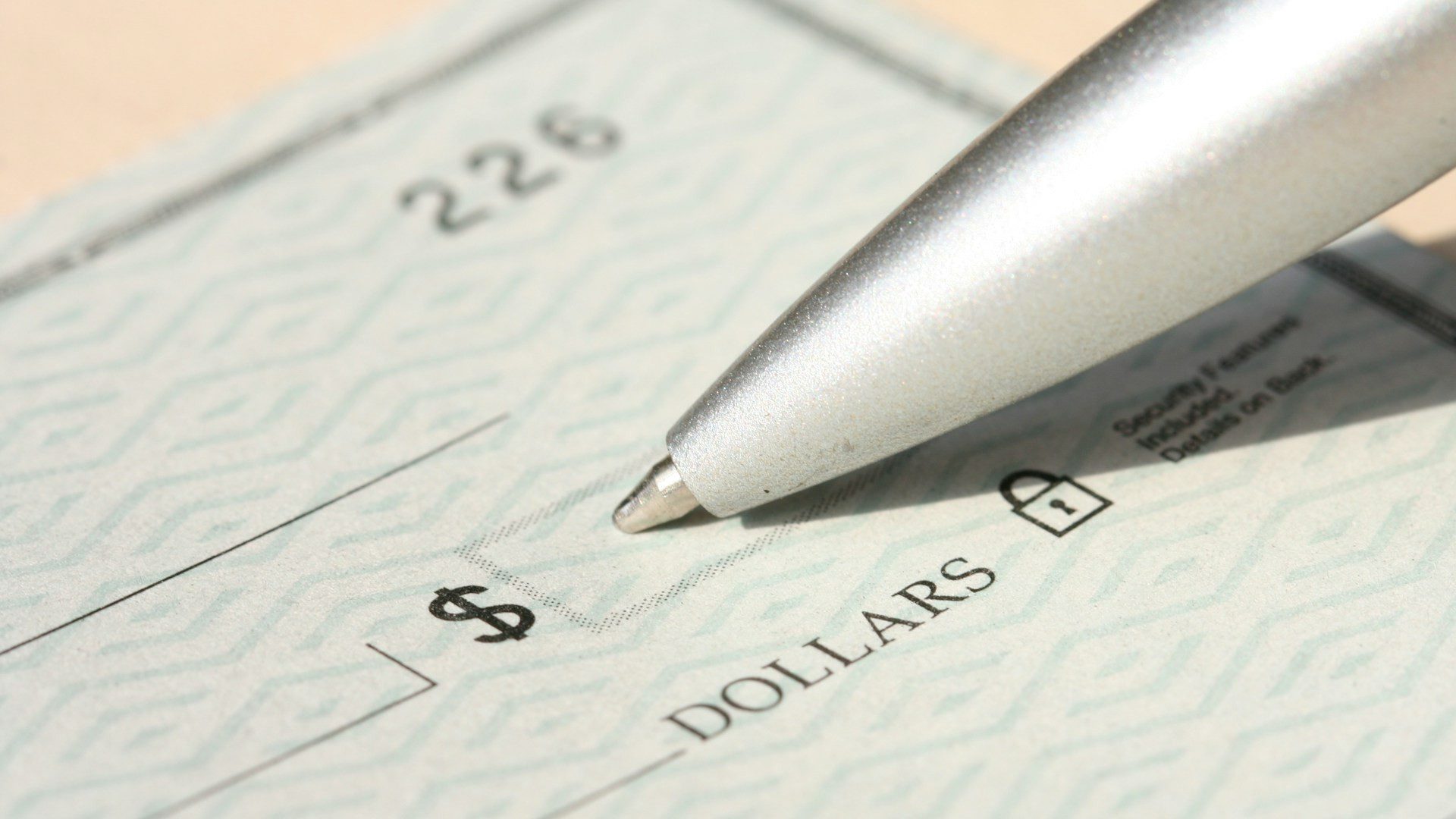 A pen resting on a blank check.