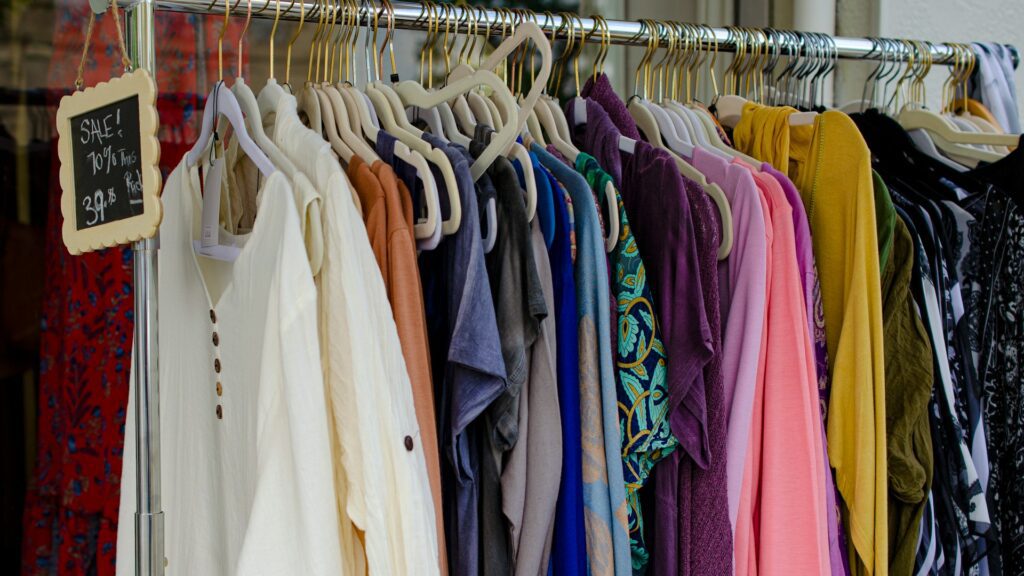 Clothes hanging on a rack in a secondhand shop.
