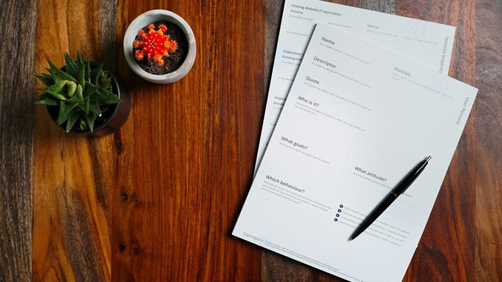 Printed forms and a pen on a wooden table for donation records.