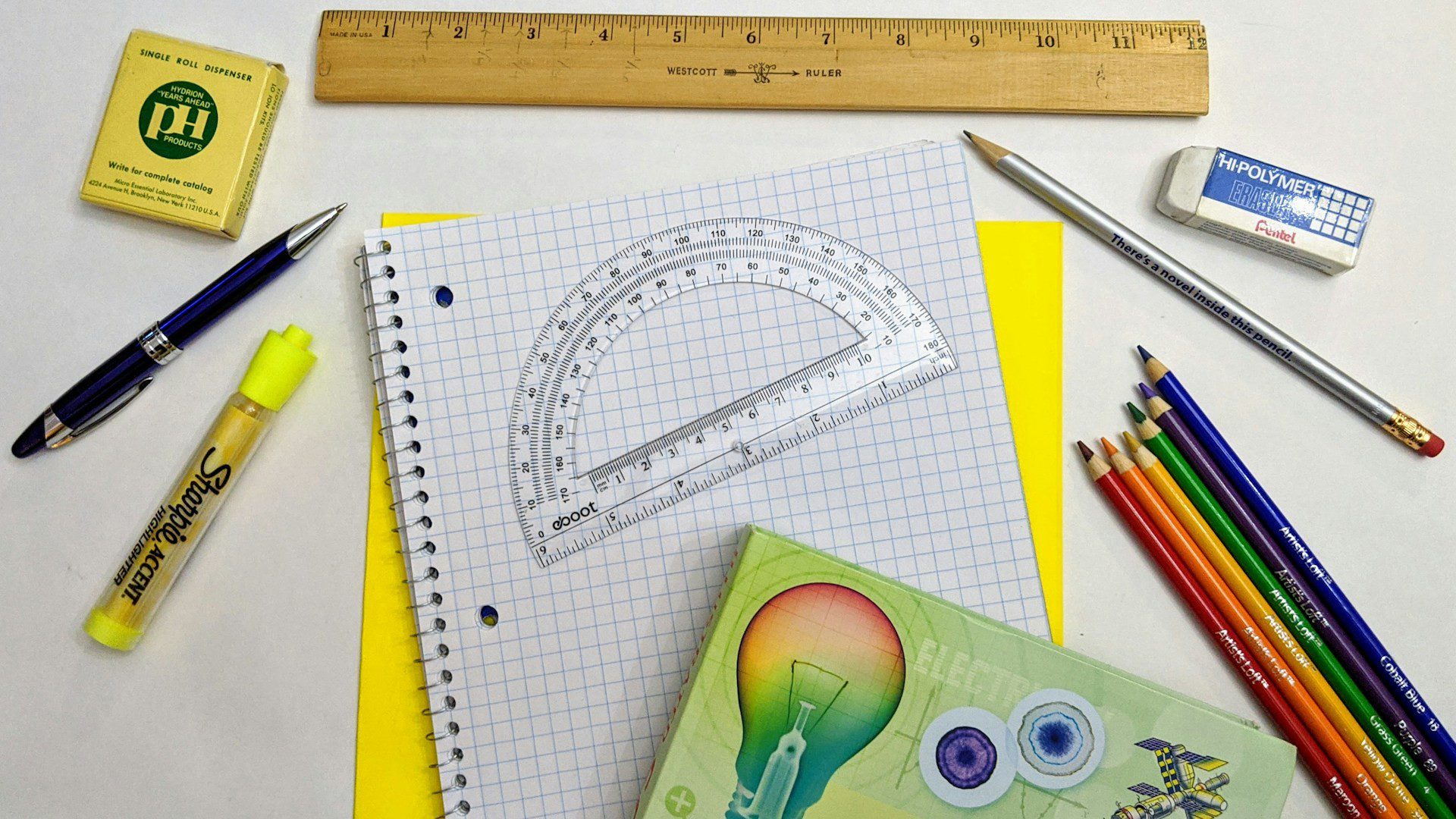 Back to school supplies laid out on graph paper.