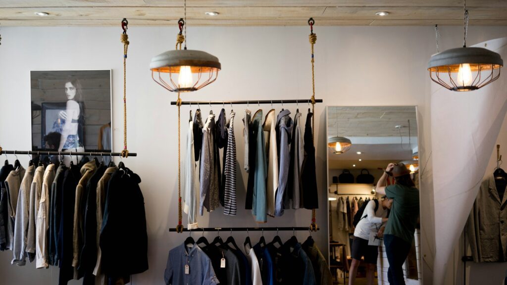 A clothing boutique with garments on hanging racks.