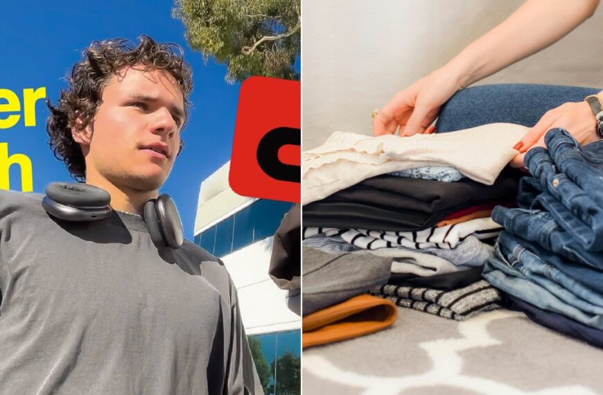 A young reseller with headphones beside a neat stack of folded clothes and jeans.
