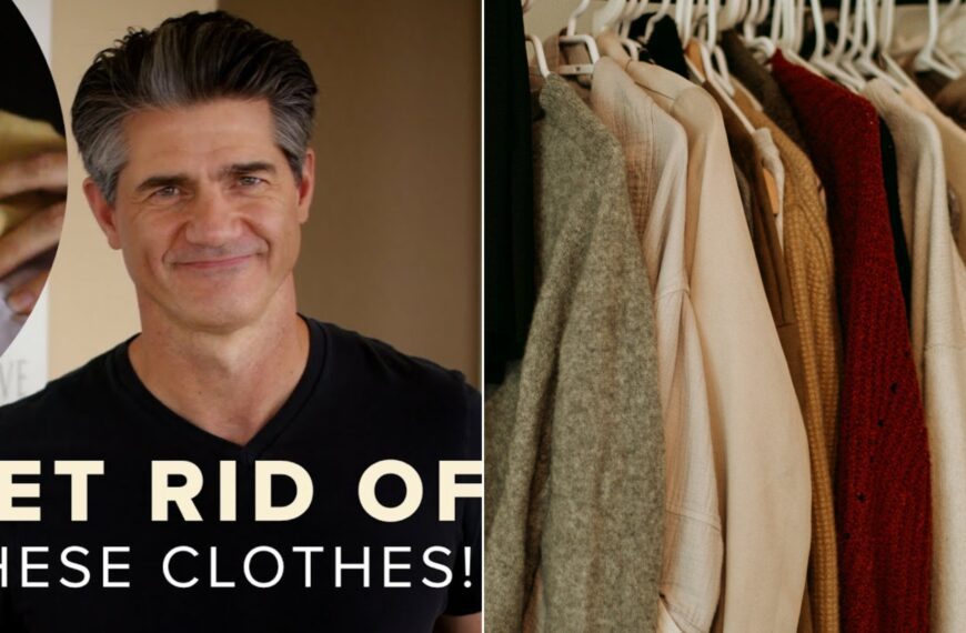 A man in a black shirt beside a coat hanging on a rack in a clothes closet.
