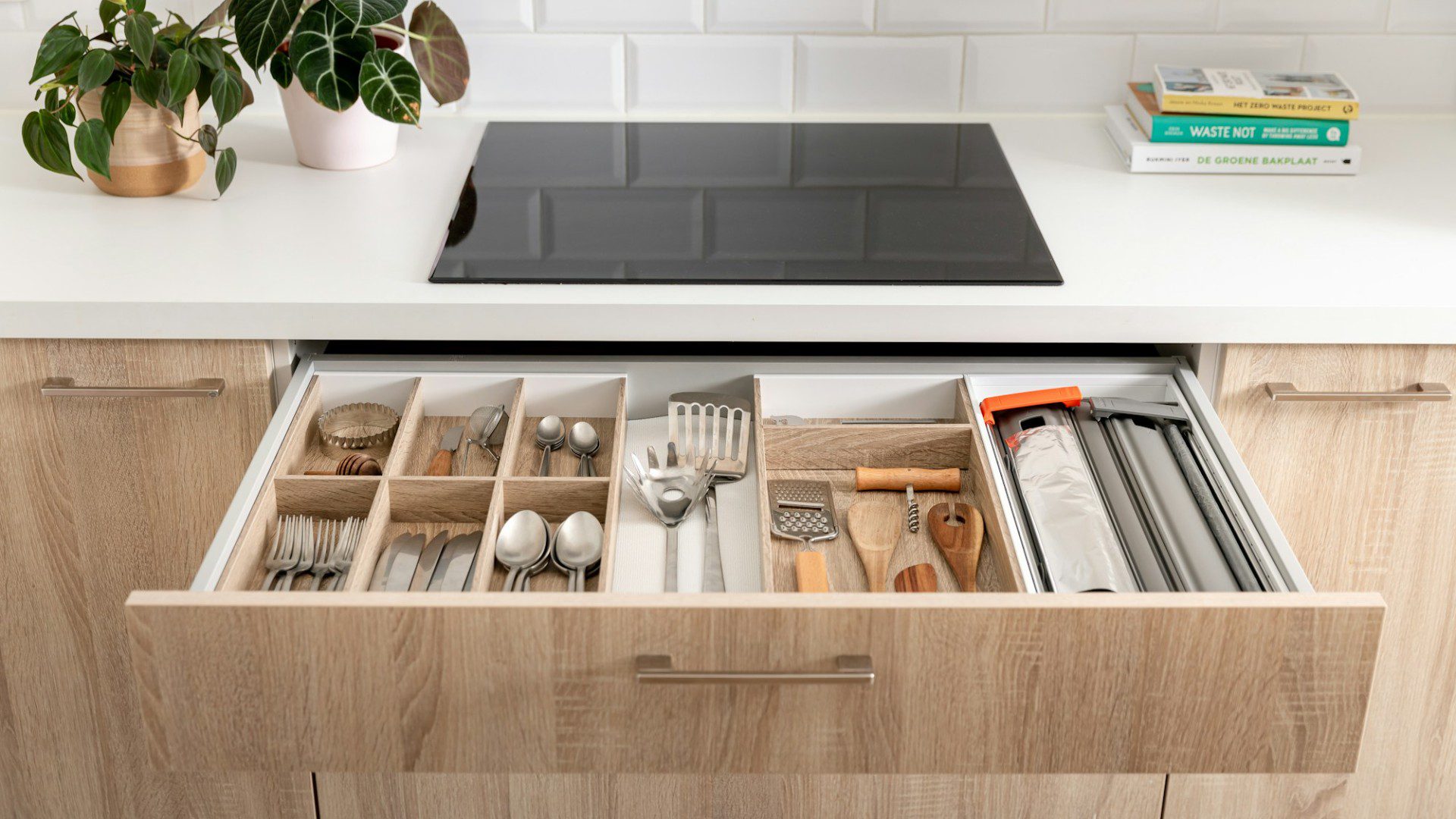 An open kitchen drawer filled with utensils and small tools (Unsplash photo by Orgalux).