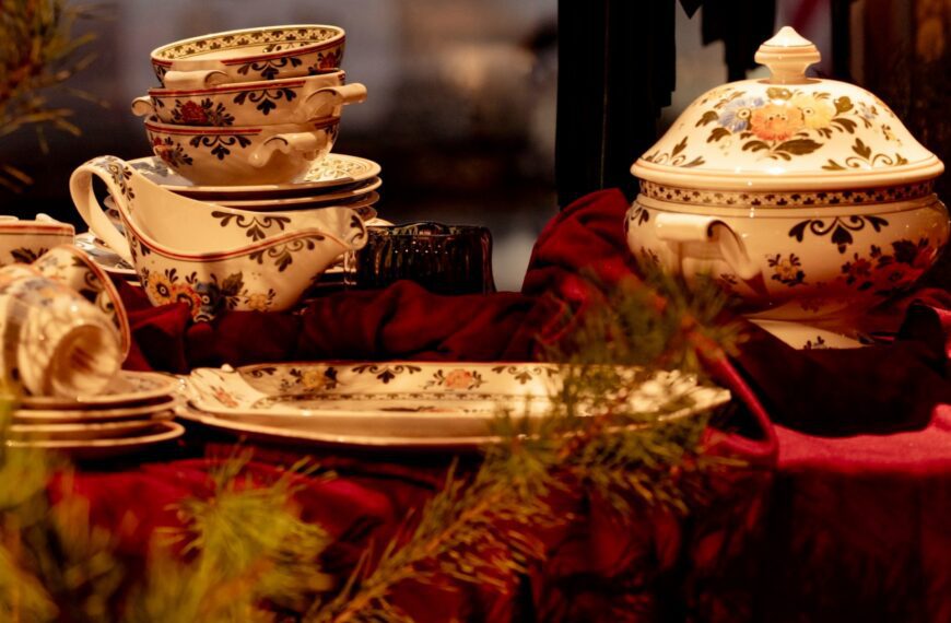 A holiday table set with patterned teacups, plates and a covered tureen (Unsplash photo by laura adai).