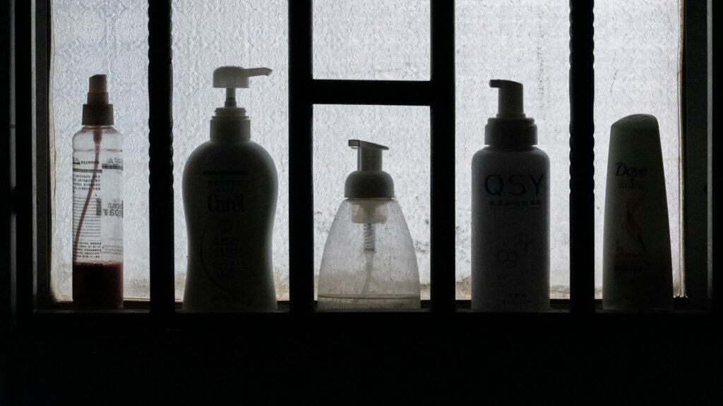 Unsplash photo by Lingchor showing three toiletry bottles on a black wooden shelf