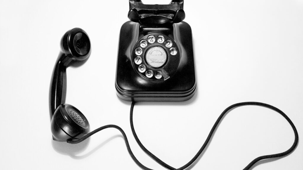 Unsplash photo by Quino Al showing a black rotary dial phone on a white surface