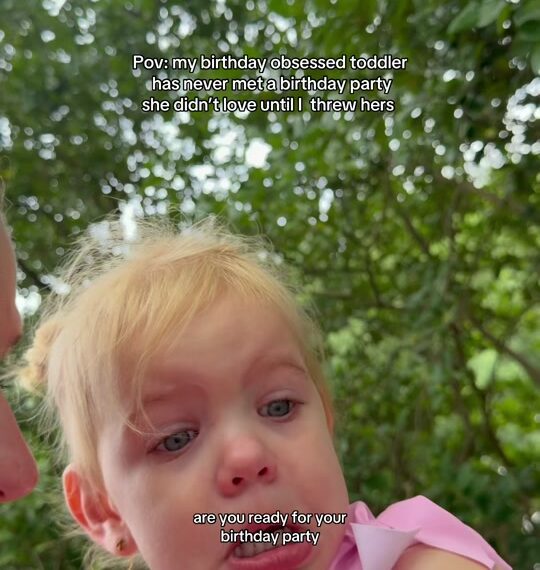 A mom holding her toddler daughter, dressed in a pink birthday girl swimsuit, on the way to the birthday party thrown for her (still from the creator's TikTok video)