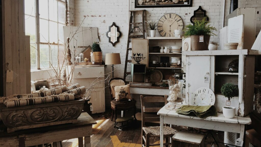 A white wooden cabinet and table fill a quiet vintage room.