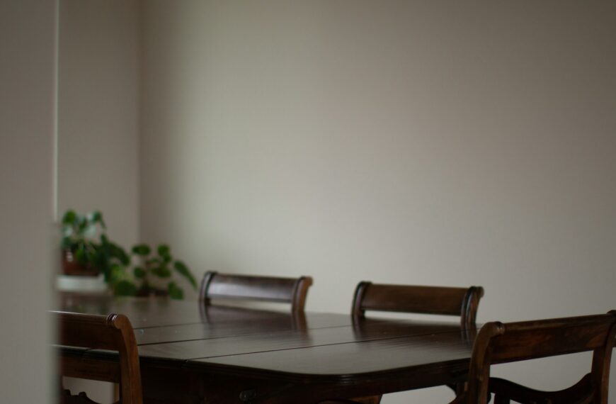 An empty wooden dining table with chairs sits ready for a family meal.