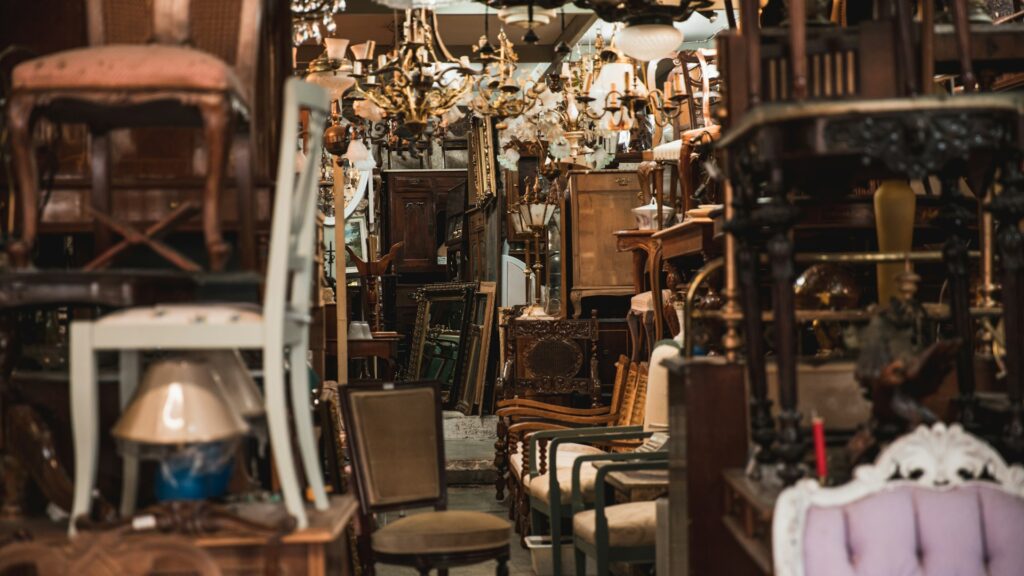 Colorful secondhand chairs fill a crowded vintage furniture shop.