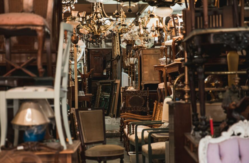 Colorful secondhand chairs fill a crowded vintage furniture shop.