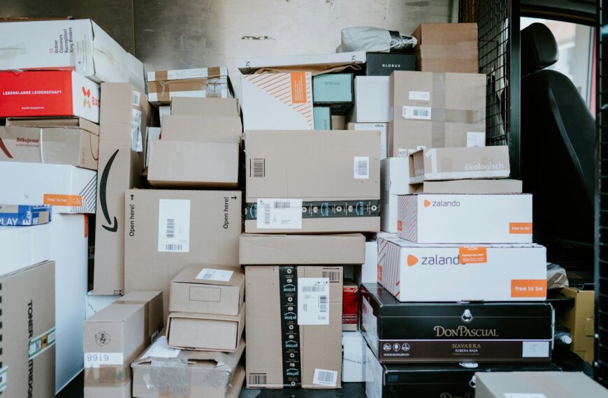 A stack of cardboard shipping boxes inside the back of a delivery van.
