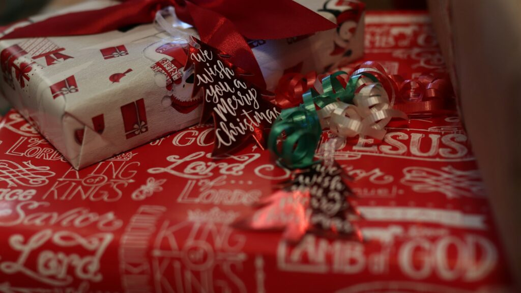 Wrapped Christmas gifts in red and white paper sit together.