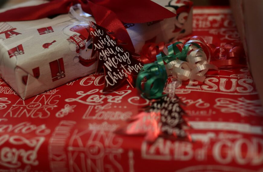 Wrapped Christmas gifts in red and white paper sit together.