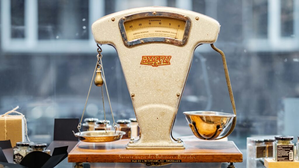 A small brown and beige weighing scale on a table.