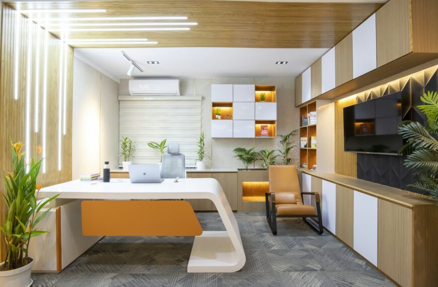 A tidy office desk with a chair in a bright room.