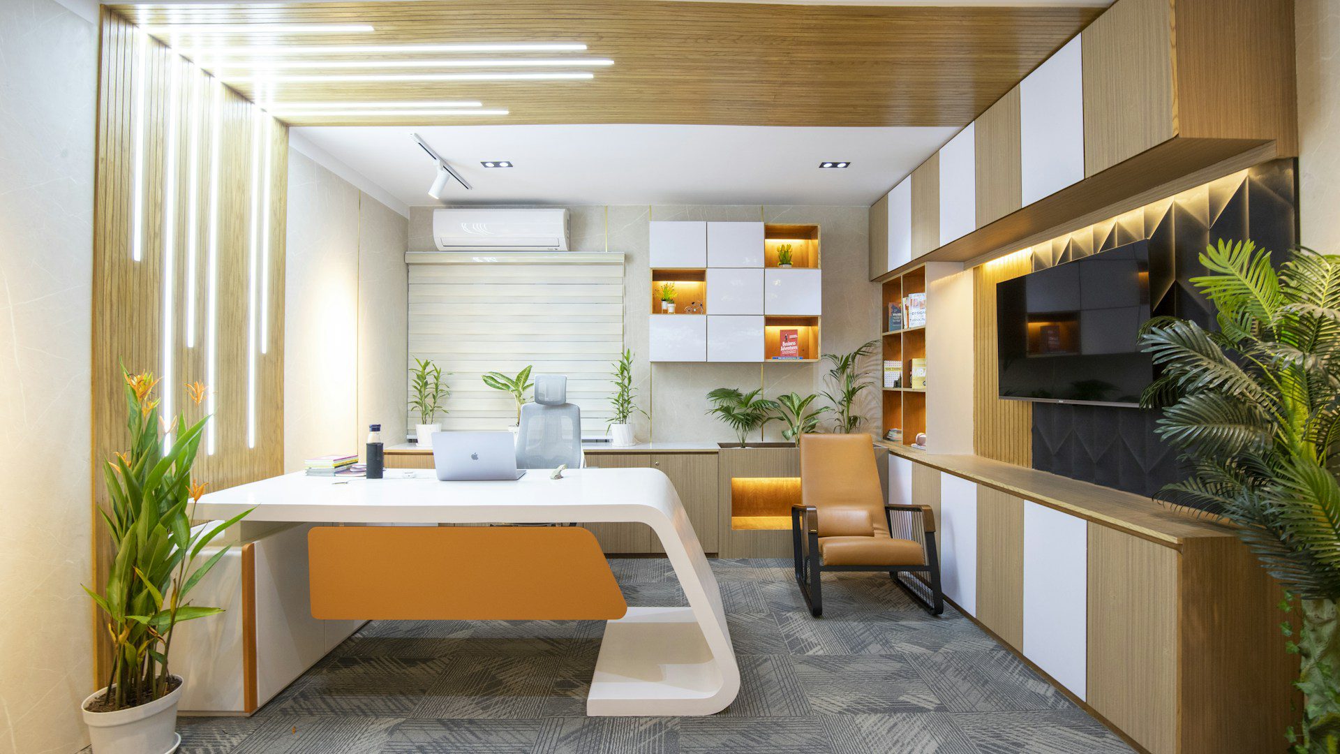 A tidy office desk with a chair in a bright room.