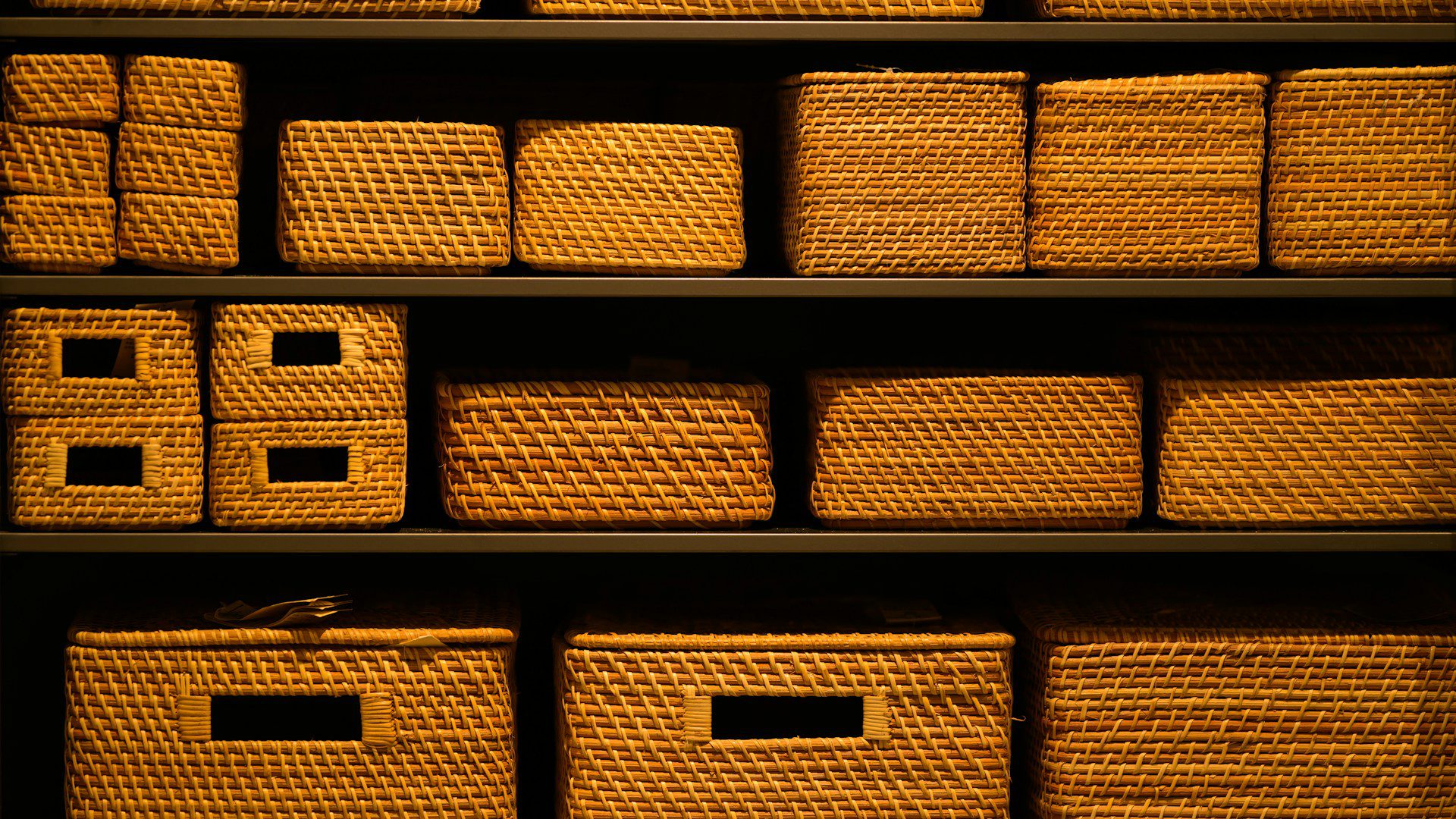 A shelf filled with neatly arranged wicker baskets.
