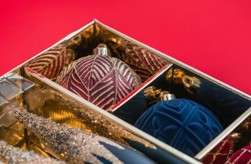 A box filled with Christmas ornaments sitting on a table.