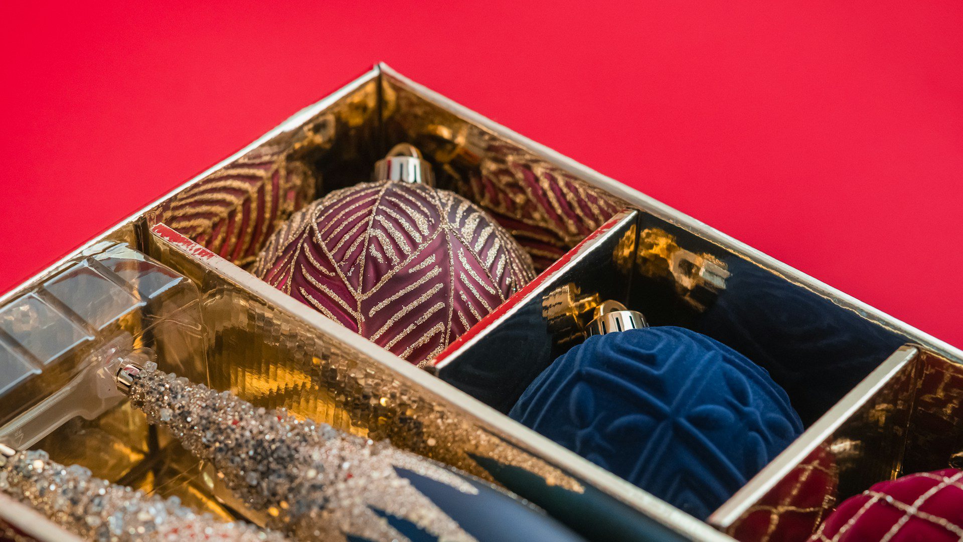 A box filled with Christmas ornaments sitting on a table.