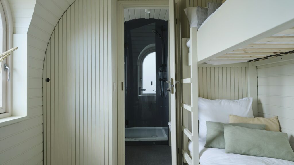 A bedroom with bunk beds beside a window.