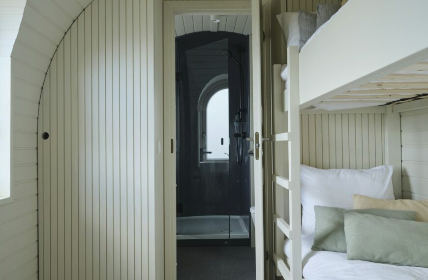 A bedroom with bunk beds beside a window.