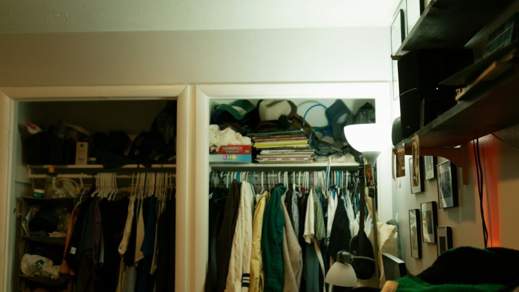 A crowded closet full of clothes and household items.