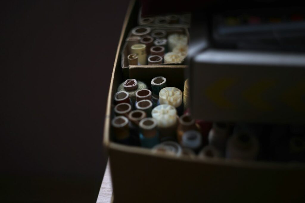 A vintage sewing basket with spools of thread