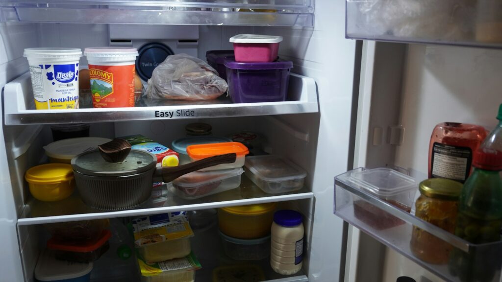 An open refrigerator is filled with neatly stored food containers.