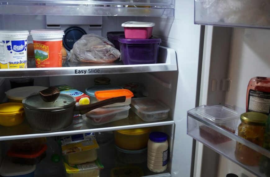 An open refrigerator is filled with neatly stored food containers.