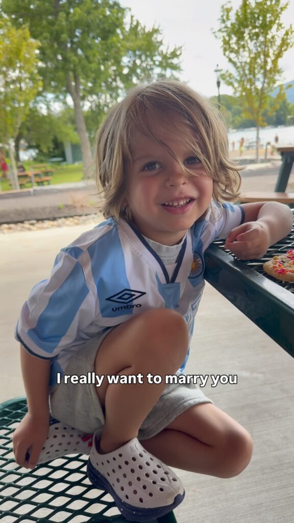 Still from the mysleepfriend Instagram reel about a young boy at a park picnic table explaining why he wants to marry his mom